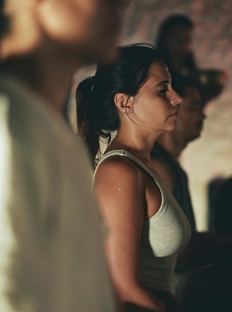 Image of a woman in a group meditation in intense concentration.